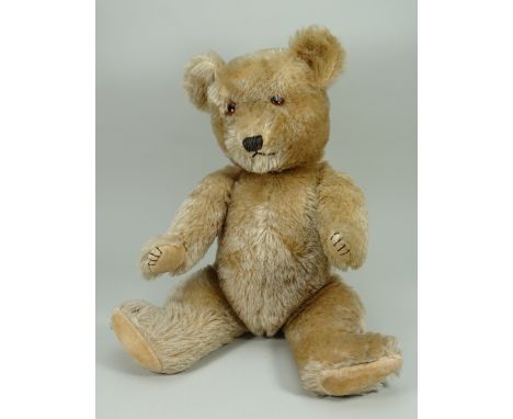 A Chiltern ‘Hugmee’ Teddy bear, English 1930s, the light brown mohair bear with amber and black glass eyes, black stitched no