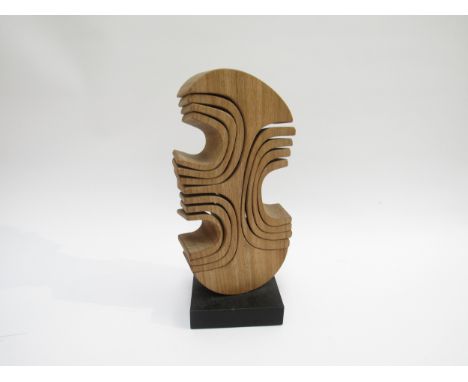 JOHN SPIELMAN (b.1944) A carved wooden abstract sculpture on ebonised base. Stamped mark. 28cm high 