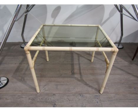 A 1970's glass topped side table with faux bamboo metal legs, 40cm high, 50cm long 