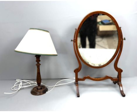 A dressing table mirror with hinged oval glass, 63cm, and a turned wooden table lamp on dished base, (2).&nbsp;