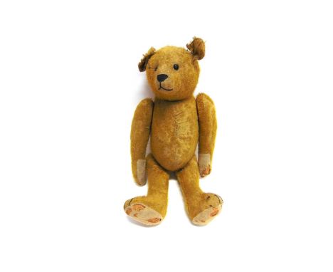 A GOLD MOHAIR TEDDY BEAR  with boot button eyes and a black horizontally stitched nose, on a jointed body with cream felt pad