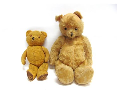 A PALE GOLD PLUSH TEDDY BEAR  with glass eyes and the remains of a black vertically stitched nose, on a jointed body with cre