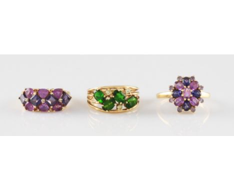 A 9ct yellow gold purple stone cluster ring, set with seventeen purple stones varying in tone in a flower head formation, hal