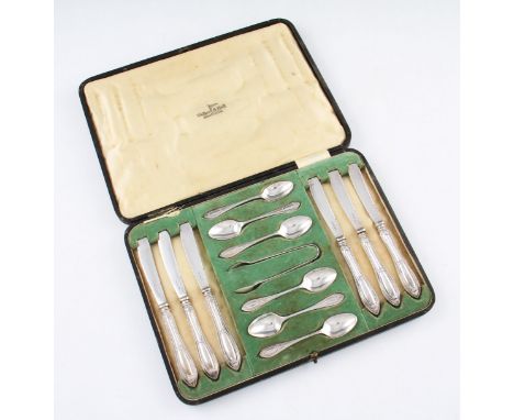 A boxed Walker &amp; Hall silver cutlery set, comprising of six knives, six spoons and a pair of sugar tongs, all of scroll d