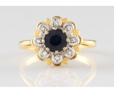 An 18ct yellow gold sapphire and diamond ring, of flower head formation, set with a central round cut sapphire surrounded by 