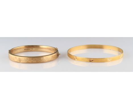 A 9ct yellow gold hinged bangle, half of the bangle engraved with repeat floral design, complete with safety chain (A/F), hal