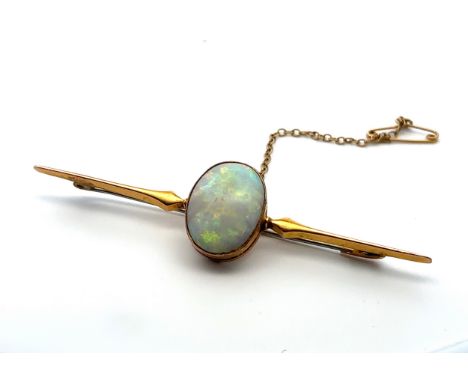 An opal bar brooch stamped 9ct. Opal approx 18 x 13mm. Weight 4.53g. Length 7.5cm. Opal with lots of play of colour and displ