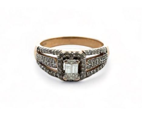A 9ct diamond cluster ring ring with central baguette cut diamond, size P. Baguette diamond 5.91mm x 3.43mm. Sponsor TGCC.
