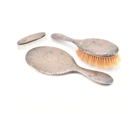 A hallmarked Edwardian silver harlequin dressing table set. The set to include brush 1908, mirror 1909 and trinket pot 1905. 