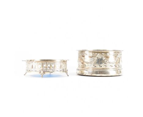 Two hallmarked silver wine coasters. A glass lined wine coaster with pierced decoration with textured blue glass liner.&nbsp;