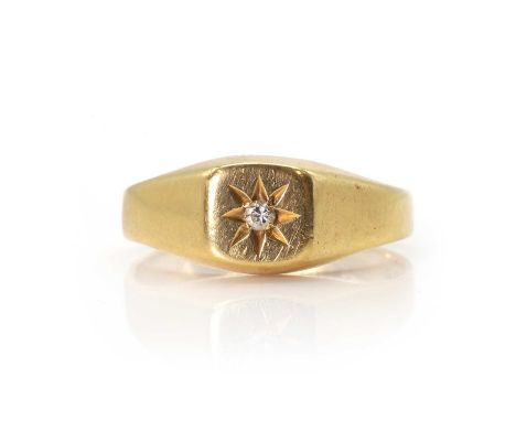 An 18ct gold diamond signet ring, with a central star set round brilliant cut diamond, to a cushion shaped head, into flat ta