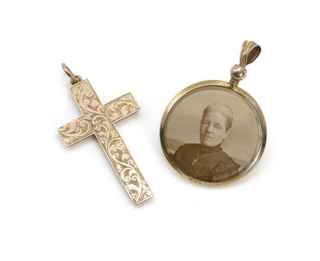 An Edwardian 9ct gold cross and a 9ct gold photo locket pendant, the gold cross with a scrolling engraved front, to an articu