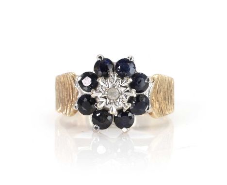 A 9ct gold sapphire and diamond cluster ring,  with a central illusion set eight cut diamond, to a surround of round brillian