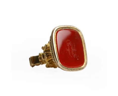 A carnelian intaglio fob seal, with a rectangular cushion shaped carnelian intaglio, set to an ornate fob seal mount with ree