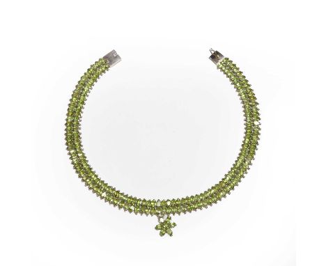 A silver peridot choker necklace, with two lines of oval cut peridot, each approximately 6mm x 4mm, suspending a flowerhead c