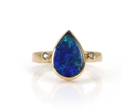 An opal doublet and diamond ring,  the drop shaped opal doublet bezel set and flanked to each side by a round brilliant cut d
