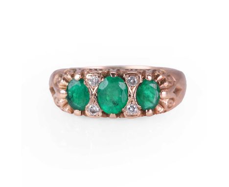 A 9ct gold emerald and diamond ring,  with three graduating oval cut emeralds, each alternating to round brilliant cut diamon