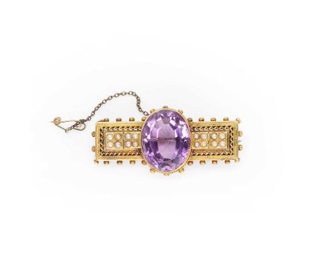 A Victorian amethyst and split pearl brooch, in the Etruscan style, centrally set with a large oval cut amethyst, flanked by 