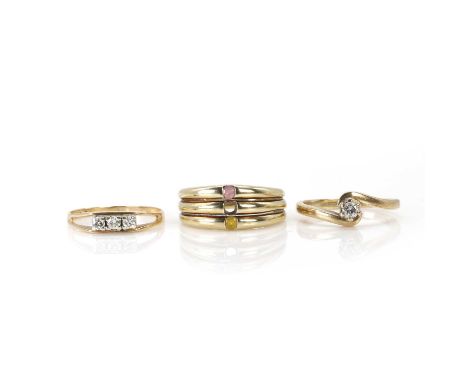 A group of three 9ct gold rings, comprising:a diamond single stone ring,a round brilliant cut diamond claw set to a crossover