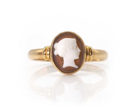 A 15ct gold shell cameo ring, with an oval shell cameo depicting a lady in profile, bezel set to banded shoulders and a D pro