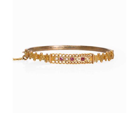 A late Victorian 9ct gold bangle, c.1893, the Etruscan style hinged bangle set with ruby and split pearl, Chester 1893, inner
