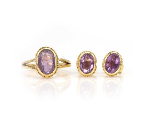 An amethyst ring and stud earrings set, the ring with an oval cut amethyst, bezel set to a twist wire effect collet, into tri