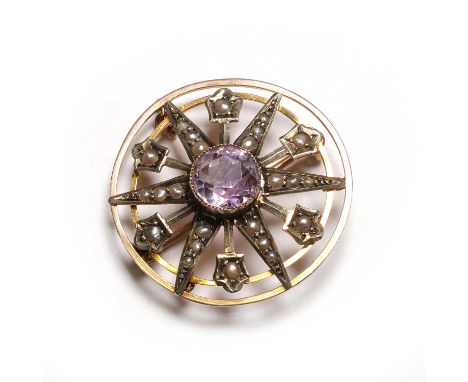 An Edwardian amethyst and seed pearl starburst brooch/pendant, with a central round cut amethyst, to an open starburst surrou