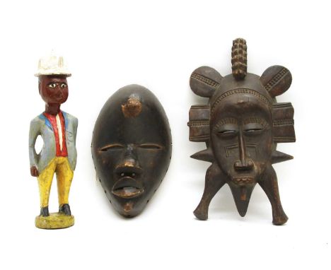 A large Cameroon (West Africa) carved wood figure of a man smoking a pipe, 48cm high, and a Dan mask (West Africa) , a Zaire 