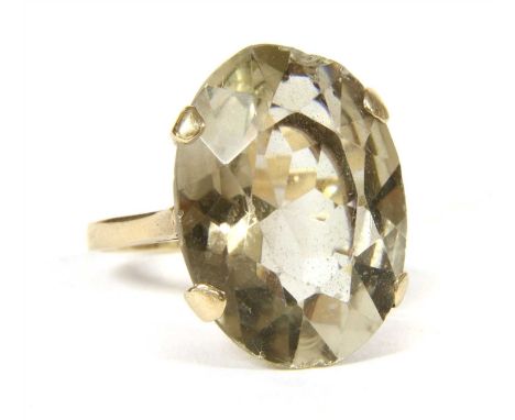 A 9ct gold smokey quartz ring, oval faceted smokey quartz, four claw set to scrolling gallery and flat profile shank, 9.40g, 