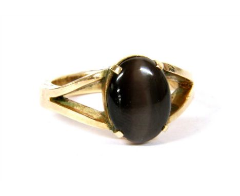 A single stone hawk's eye ring, an oval cabochon hawk's eye, four claw set to a plain collet, to split shoulders and a plain 