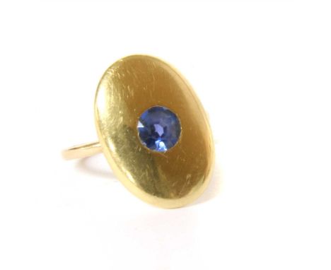 An oval cufflink later converted to a ring, rub set to the centre with a round cut synthetic sapphire, stamped 18ct gold, to 