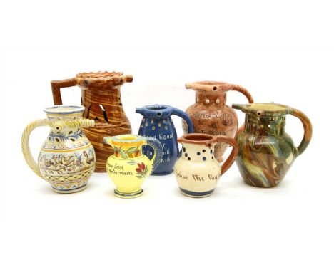 A collection of ceramic puzzle jugs, to include a Royal Doulton stoneware example, Torquay pottery, a Faience example and sim