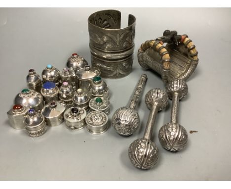 Sixteen Omani decorative silver trinket boxes, inset various semi-precious stones, a wide embossed bangle, a pair of 'cuff' b