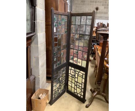An early 20th century glazed oak two fold screen, each panel width 51cm, height 176cm