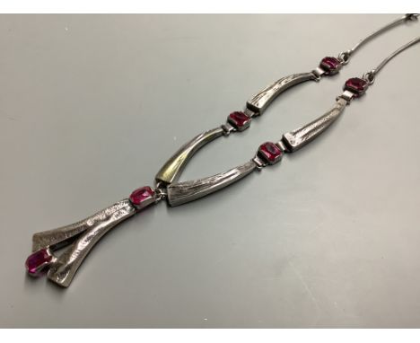 A modern stylish white metal and synthetic ruby set drop pendant necklace, 55 cm.