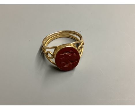 A yellow metal and carved oval Jasper set signet ring, with pierced shank, the matrix carved with two cherubs, size O gross 3