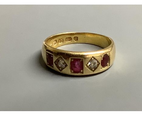 A late Victorian 18ct gold and gypsy set three stone ruby and two stone diamond half hoop ring,size N/O, gross weight 5.8 gra