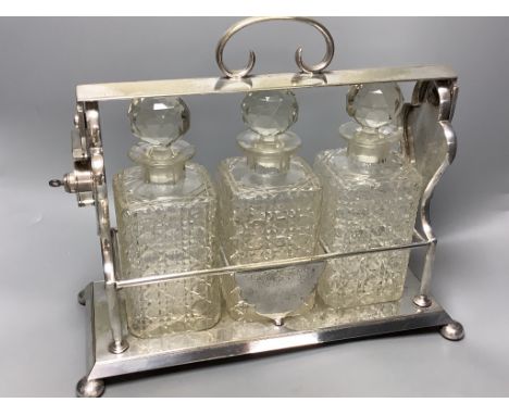 A late 19th / early 20th century silver plated three bottle tantalus, length 39cm