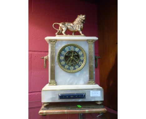 A gilt metal mounted alabaster mantle clock with lion surmount