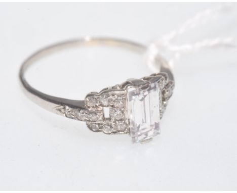 A diamond and platinum ring, the rectangular step cut central stone flanked by diamond set shoulders, central stone weight 1.