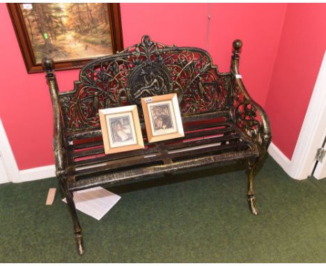 A patinated metal two seater garden bench in period style