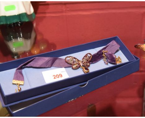 An amethyst coloured paste and gilt metal choker in the form of a butterfly.