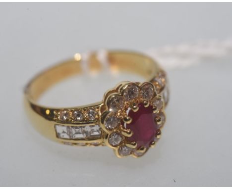 A ruby and diamond cluster ring, set in 18ct gold, the central ruby (0.8cts), surrounded by brilliant cut diamonds and with d