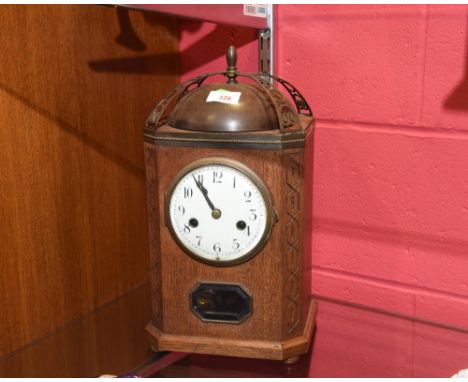 An oak cased mantel clock, surmounted by a pierced brass arches and brass dome