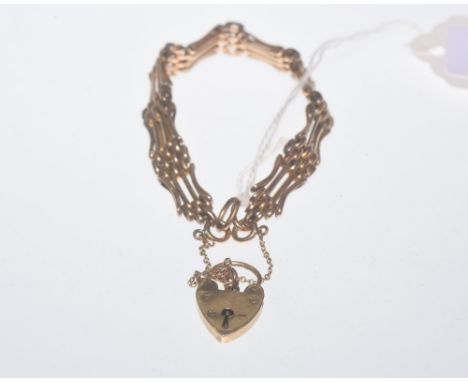 A gate link bracelet with a heart shaped locket. 