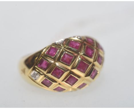 An 18ct gold, ruby and diamond bombe form ring, set with 17 square cut rubies and six brilliant cut diamonds, the band stampe