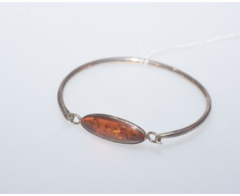 A silver bangle set with a amber coloured stone, stamped 925