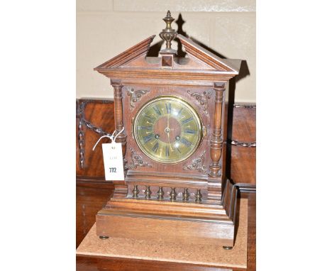 A 19th Century mantel clock in oak architectural style case, the broken swan neck pediment with central turned finial, the ci