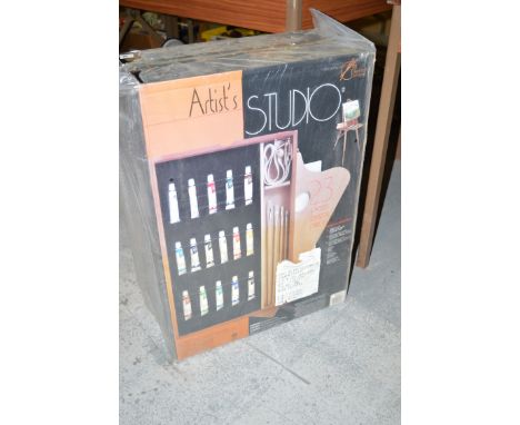 An artist's studio easel with paints, brushes, etc.