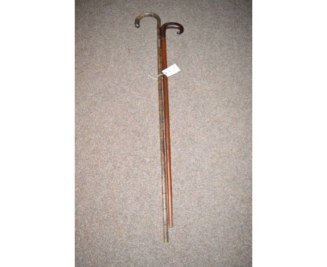 A wooden walking stick; and a bamboo simulated silver mounted walking stick.